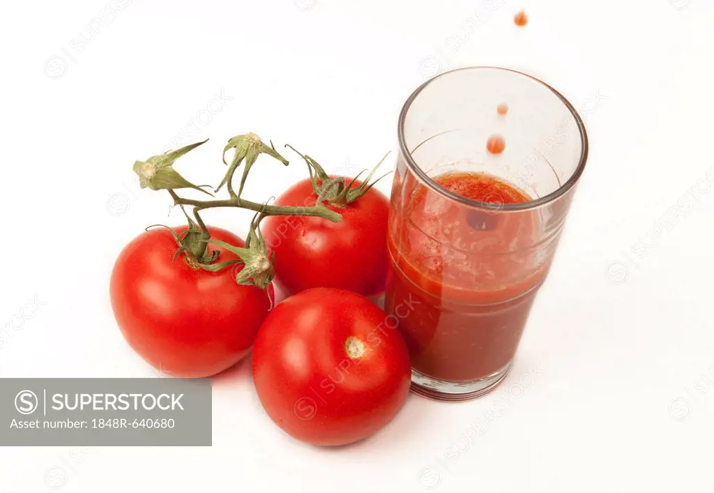Tomatoes with a glass of tomato juice
