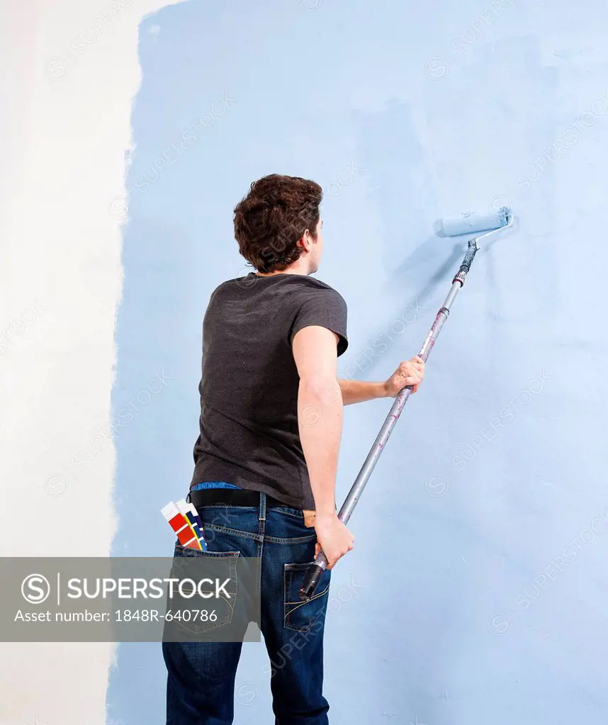 Young man painting a wall