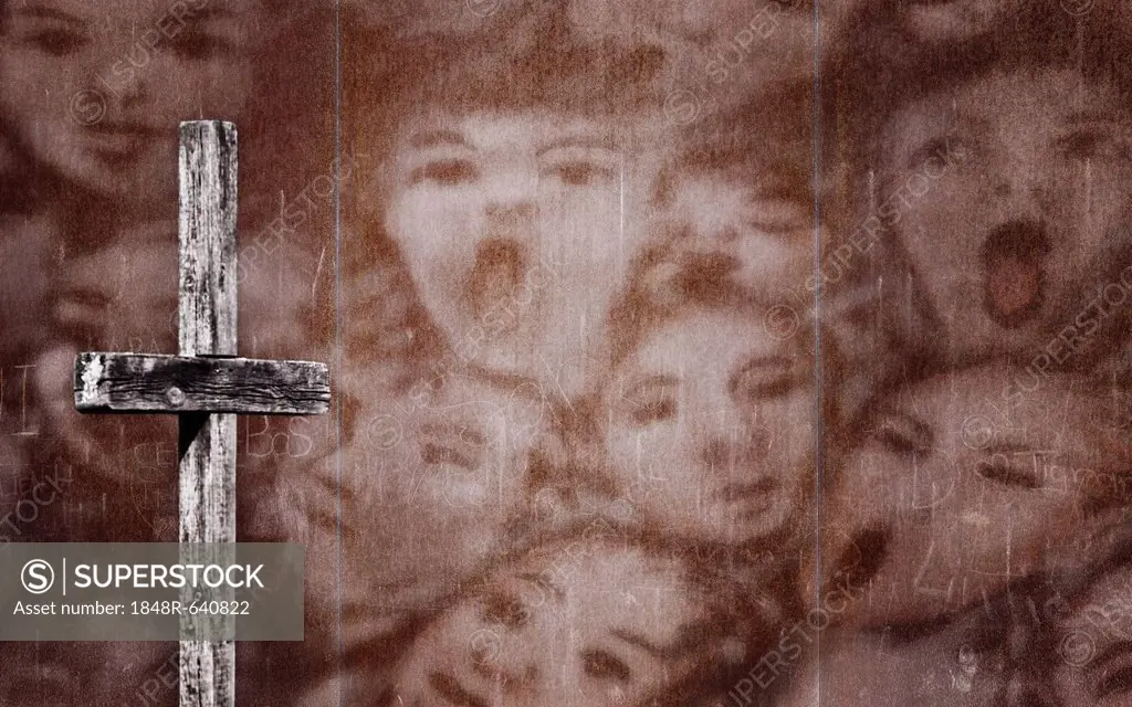 Wooden cross in front of a rusty wall with a drawing of screaming people, photomontage