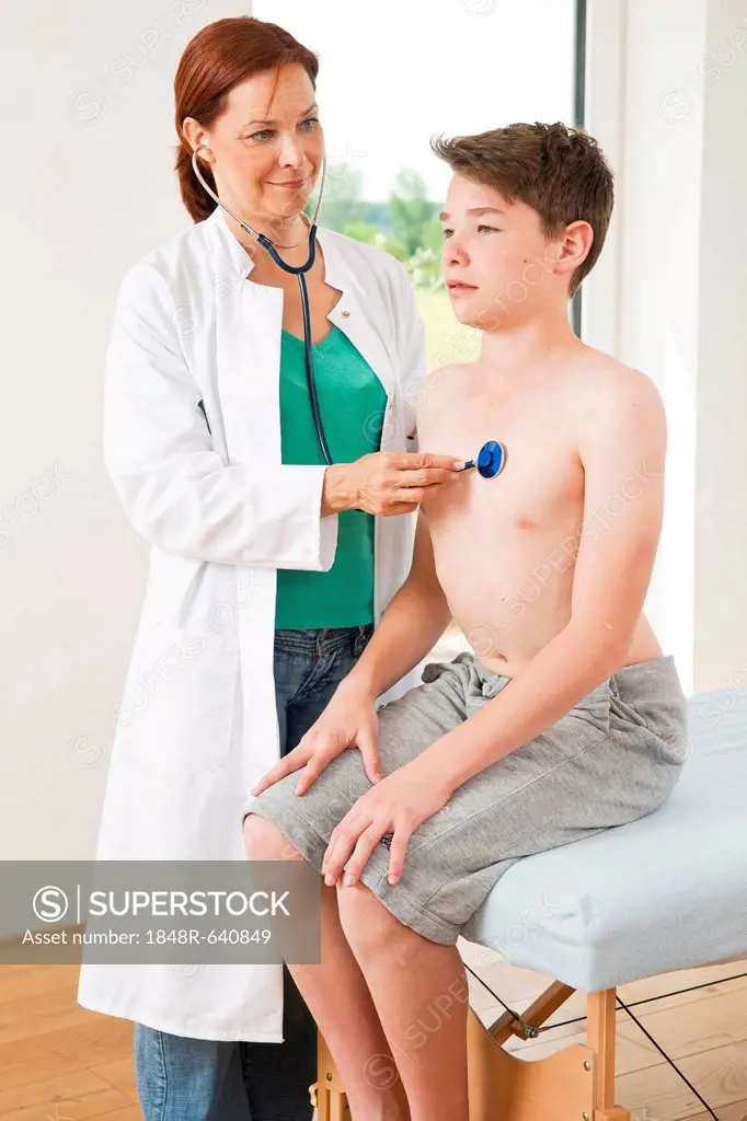 Doctor examining a teenage boy with a stethoscope