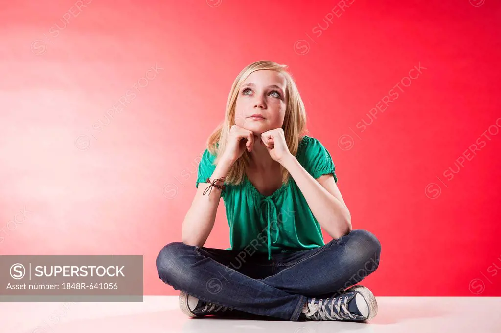 Girl with a thoughtful expression sitting cross-legged
