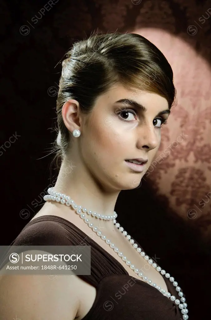 Young woman wearing a pearl necklace and pearl earrings, portrait