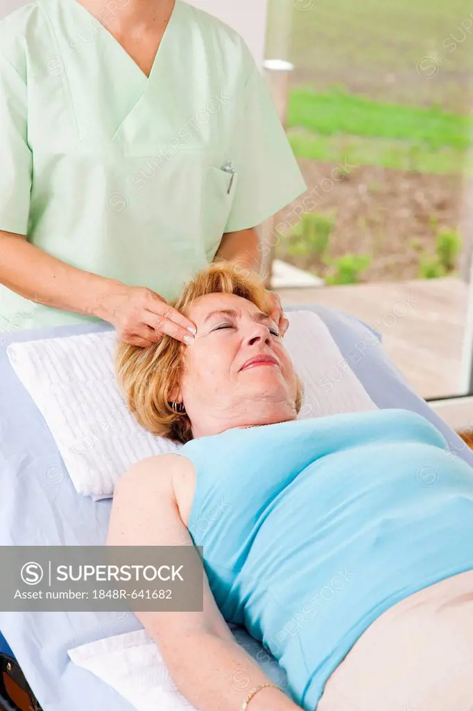 Patient being massaged on her temples by a physiotherapist