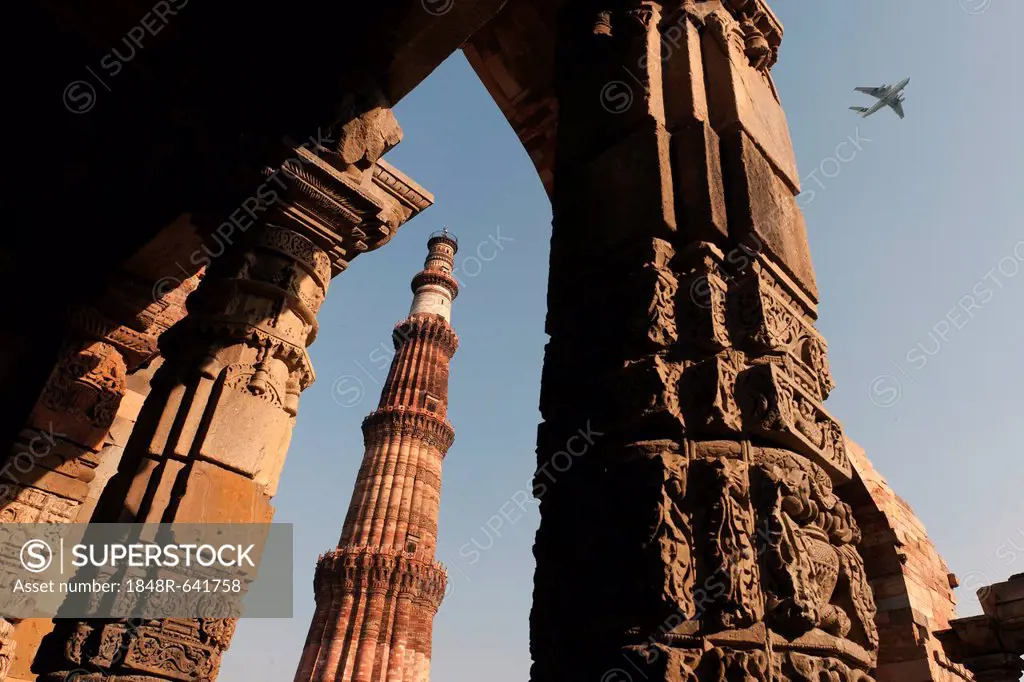Qutb Minar minaret with aircraft flying above, UNESCO World Cultural Heritage, New Delhi, India