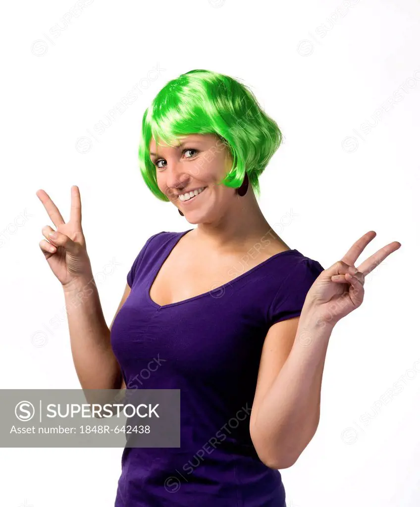 Young woman wearing a green wig, flashy, funny, making a peace sign