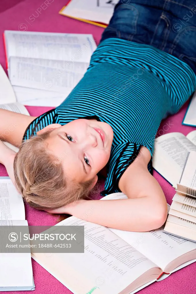 Girl, 8, lying between books
