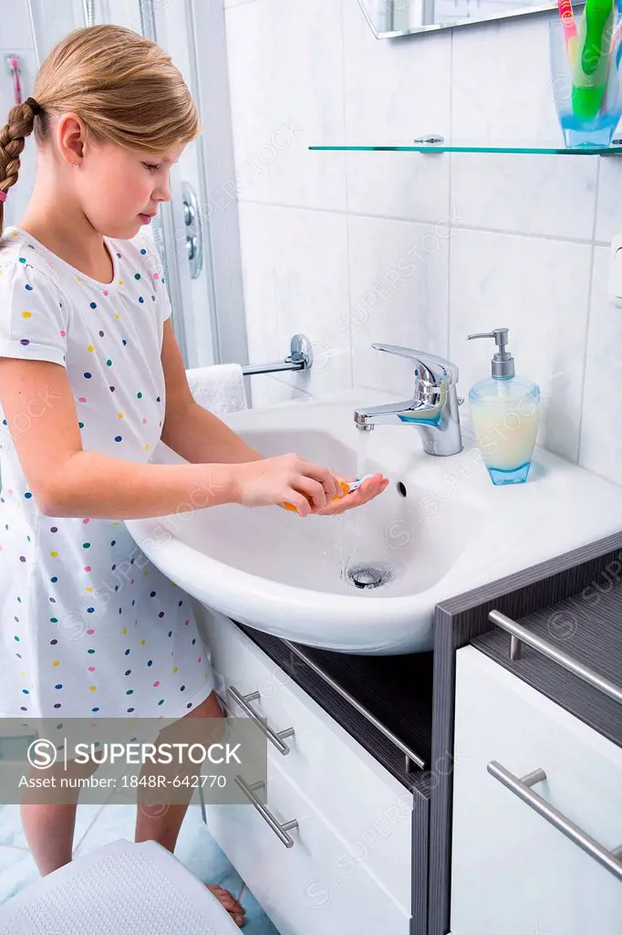 Little girl brushing her teeth in the bathroom