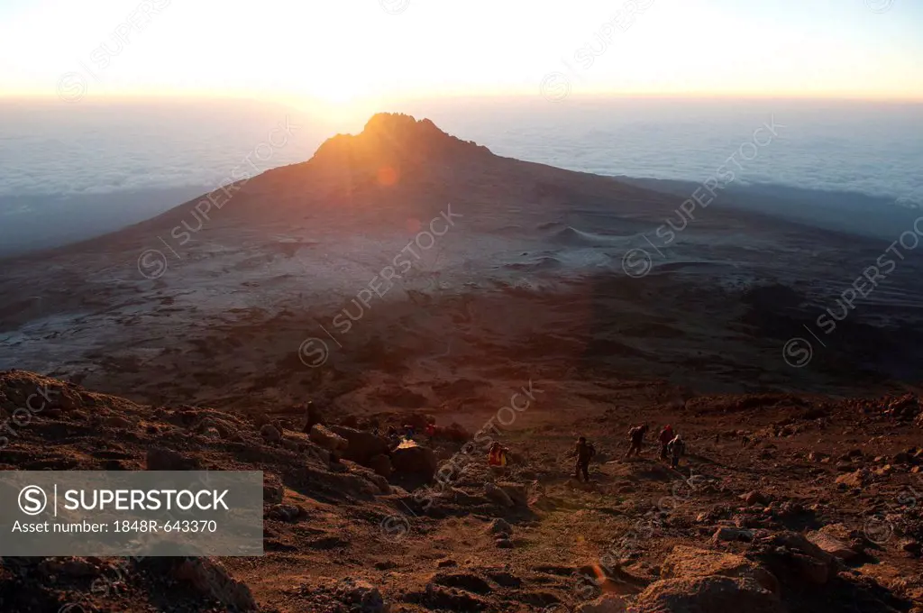 Sunrise over Mount Mawenzi, extinct volcano, mountain climbers during the ascent to the crater rim of Kibo, overlooking the Kibo Saddle, Kilimanjaro N...