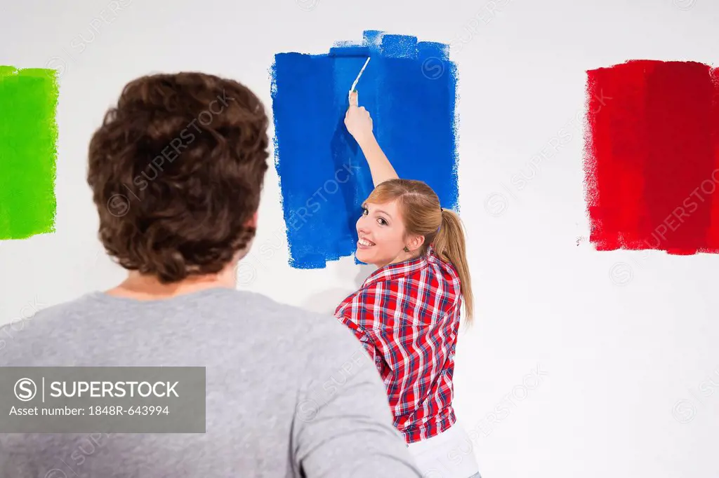Young couple sampling various wall paint colours