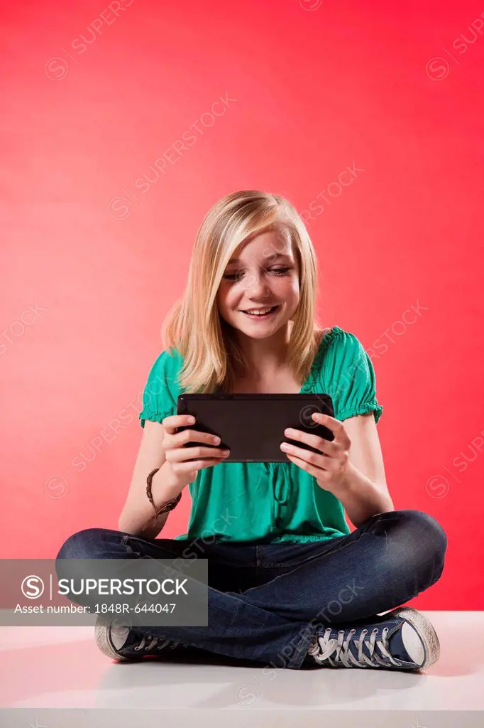 Girl sitting cross-legged while using a tablet PC