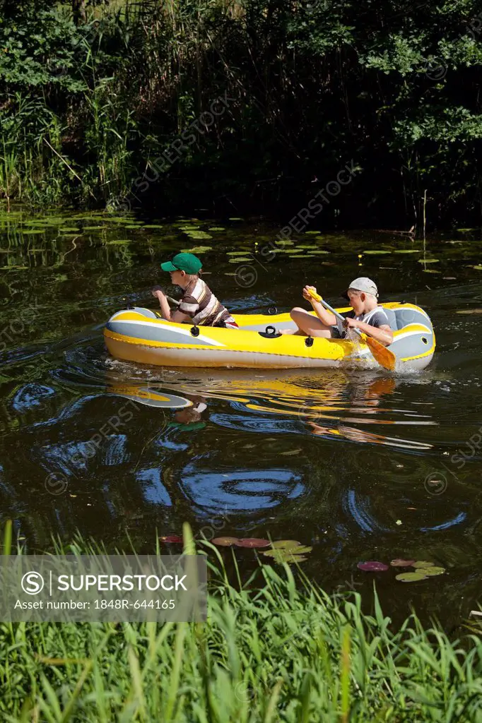 Two boys in a rubber boat in a river, Barum, Lower Saxony, Germany, Europe