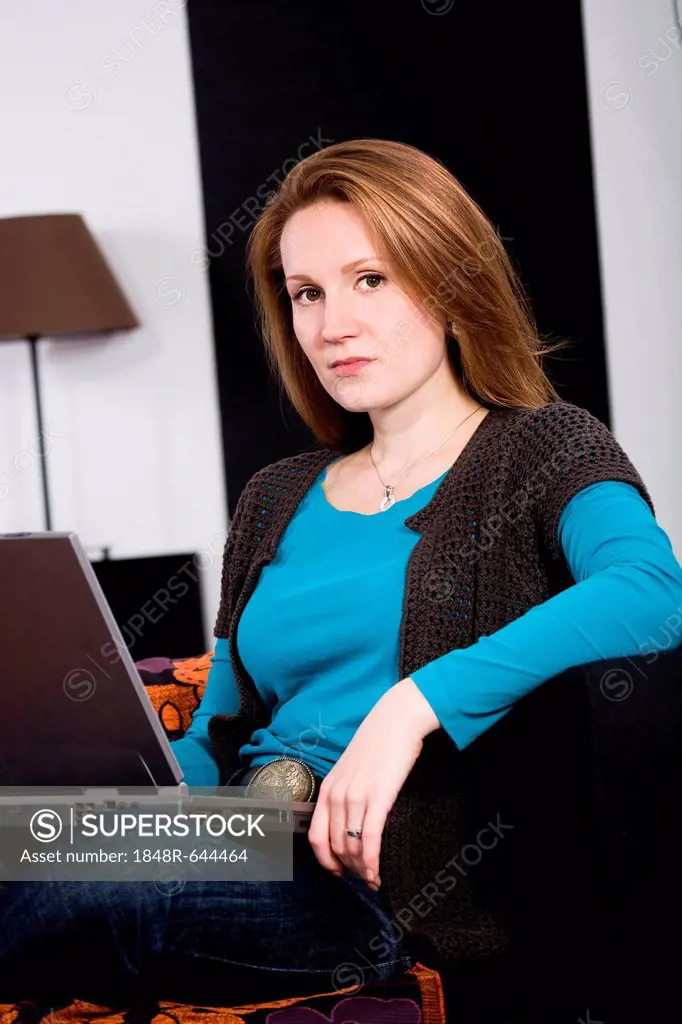 Young woman with a laptop in the living room