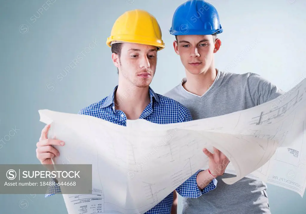 Two young tradesmen looking at a building plan