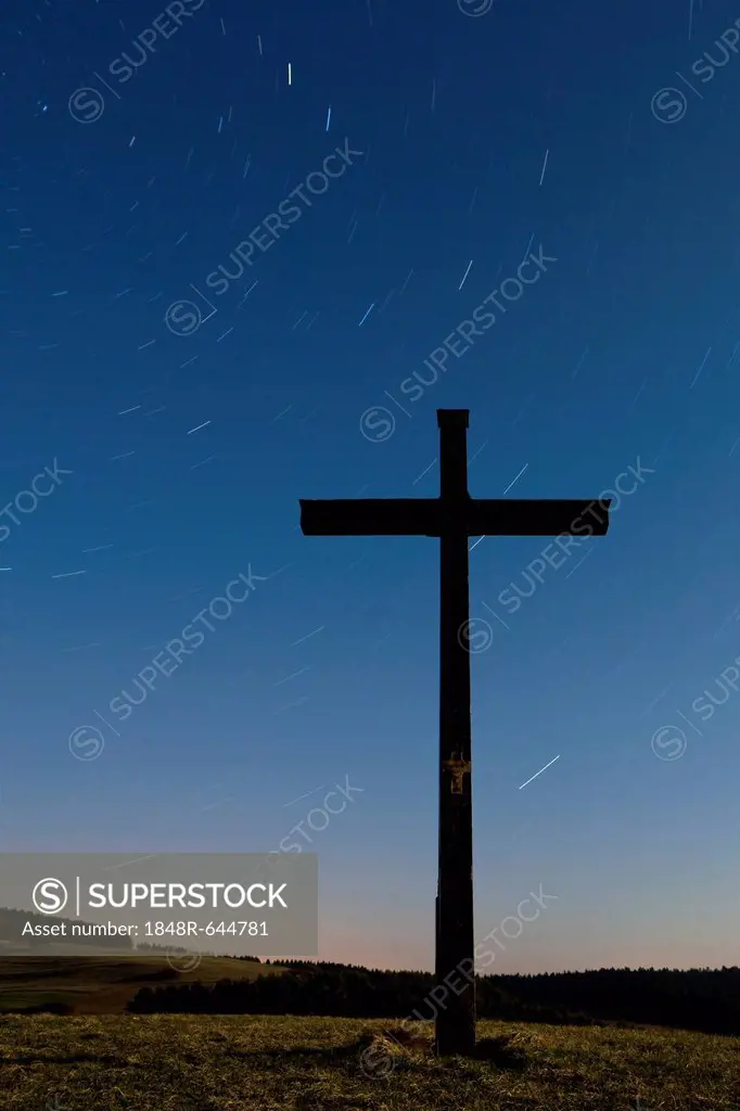Summit cross at night and star trails in the Hegau area at Watterdingen, Baden-Wuerttemberg, Germany, Europe