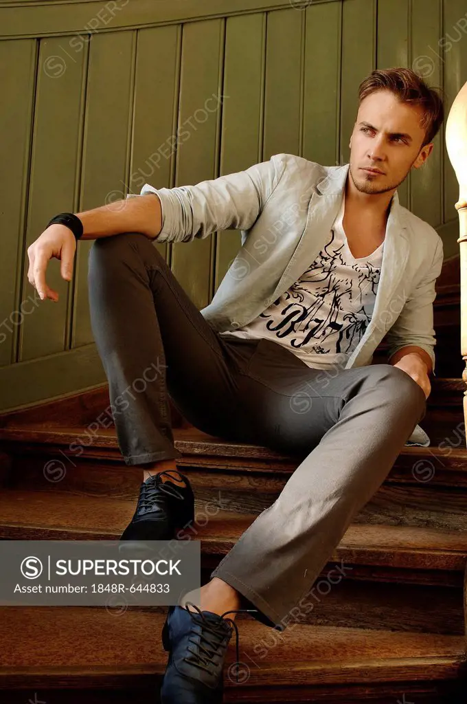 Young man dressed casually sitting on a staircase