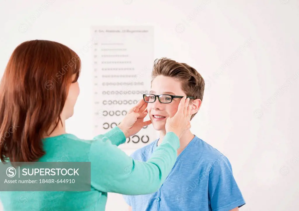 Teenage boy getting new glasses at the optician