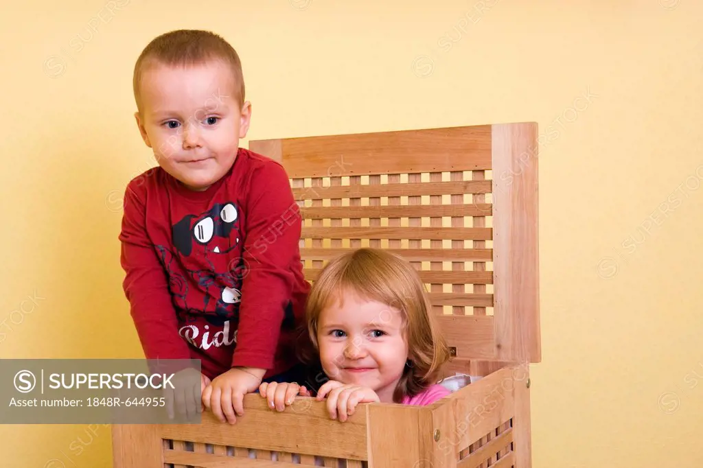 Boy, 2 years, and girl, 3 years, in a box