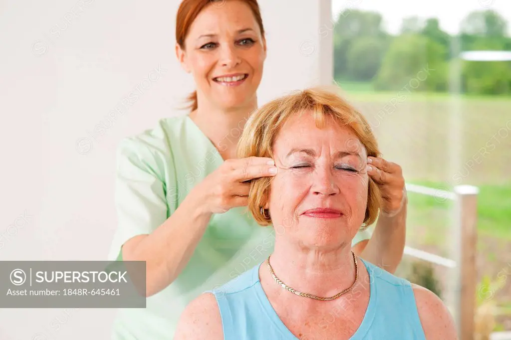 Patient being massaged on her temples by a physiotherapist