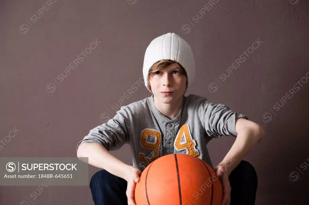 Cool boy wearing a cap and holding a basketball