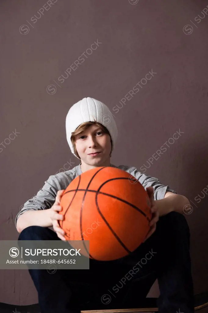 Cool boy wearing a cap and holding a basketball