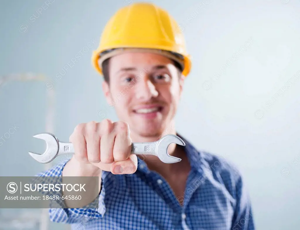 Young craftsman holding a wrench