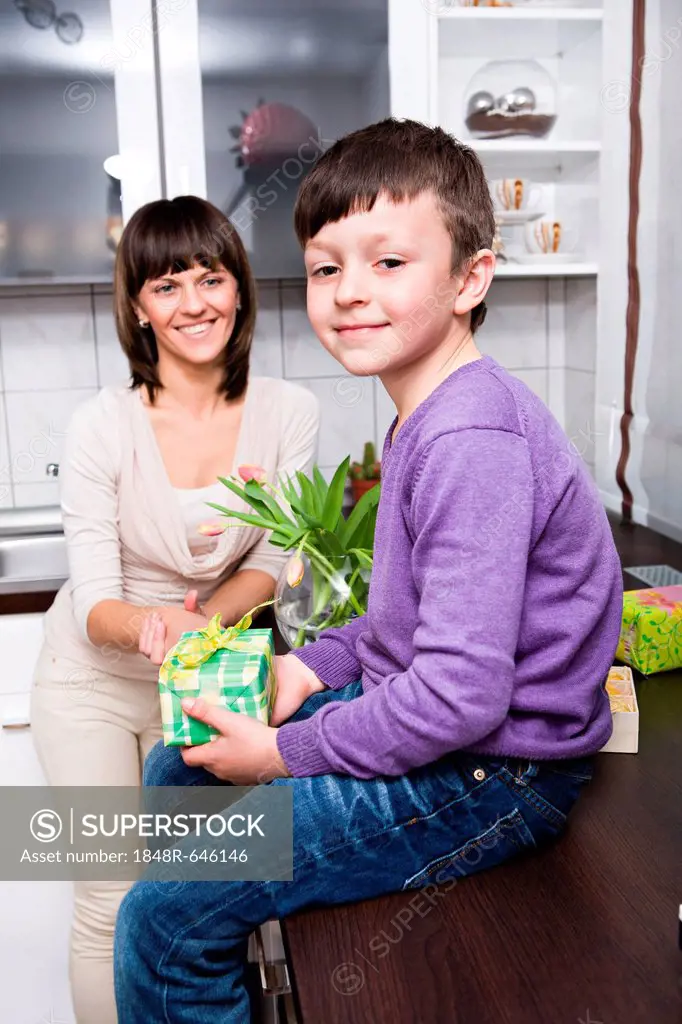 Young woman and her son in the kitchen, with Easter presents