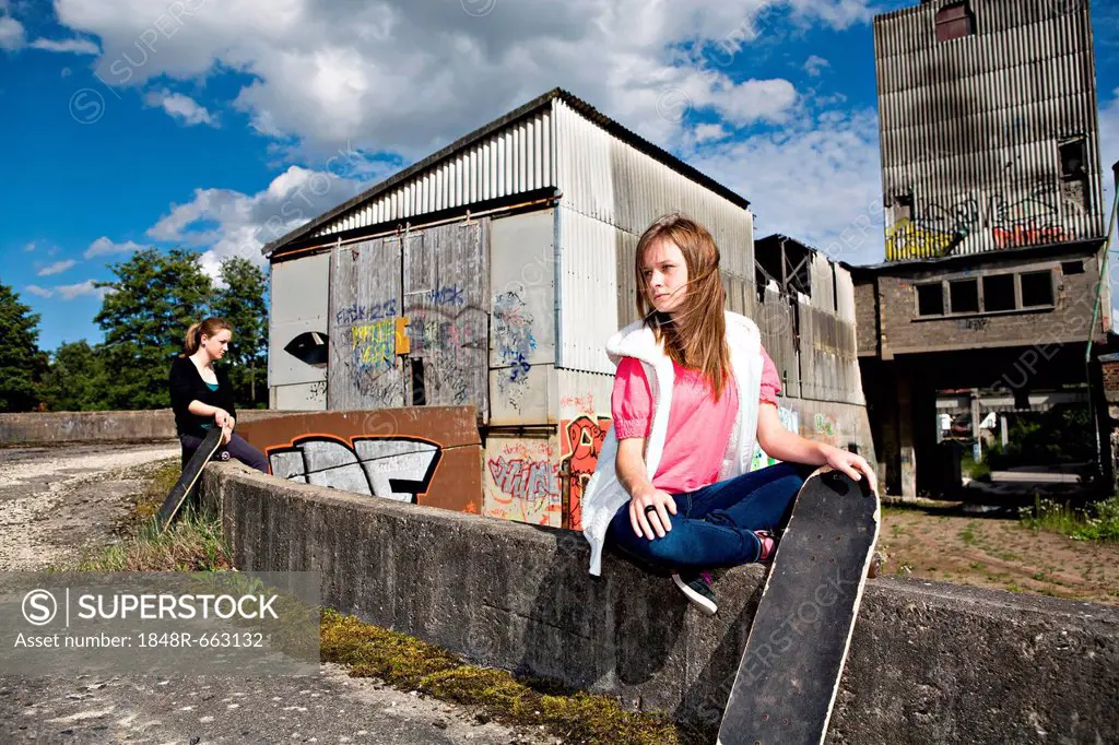 Teenage girls with skateboard in urban surroundings