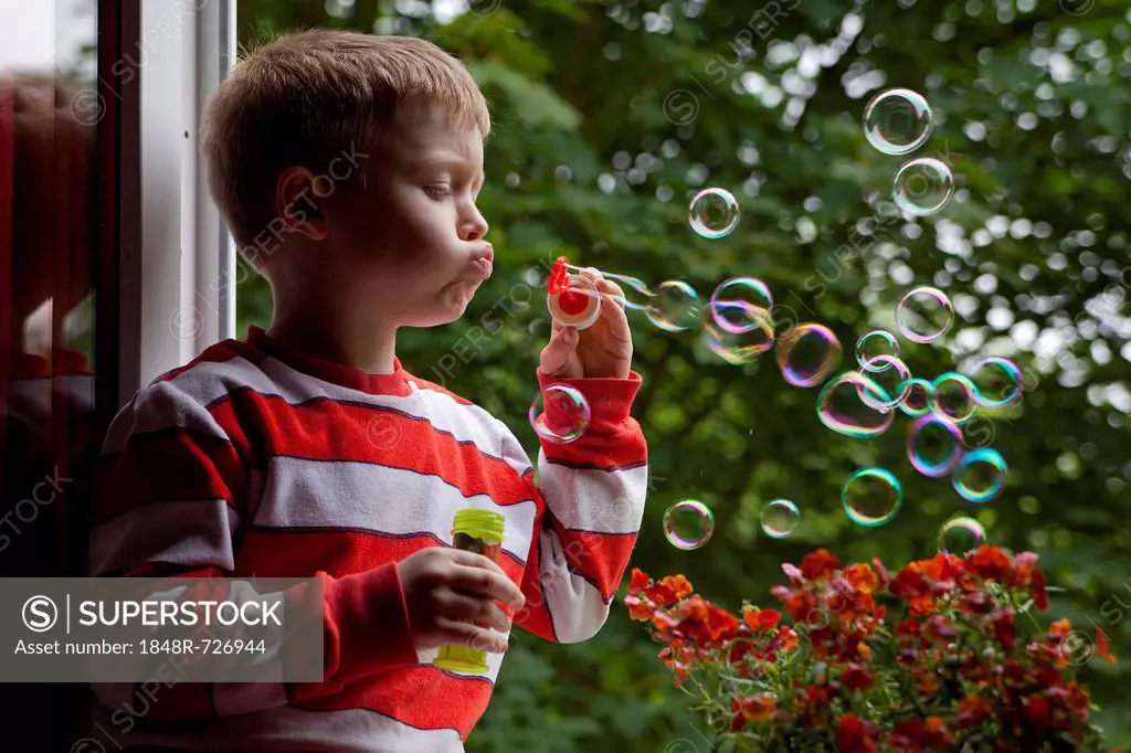 Little boy blowing soap bubbles