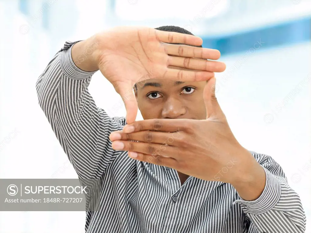 Young man, African-American, American, his hands shaping a rectangle in front of his face, gesture