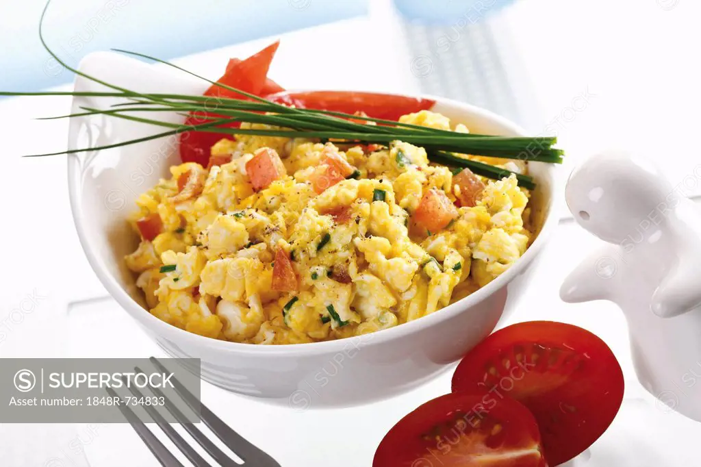Dish with scrambled eggs, tomato and chives