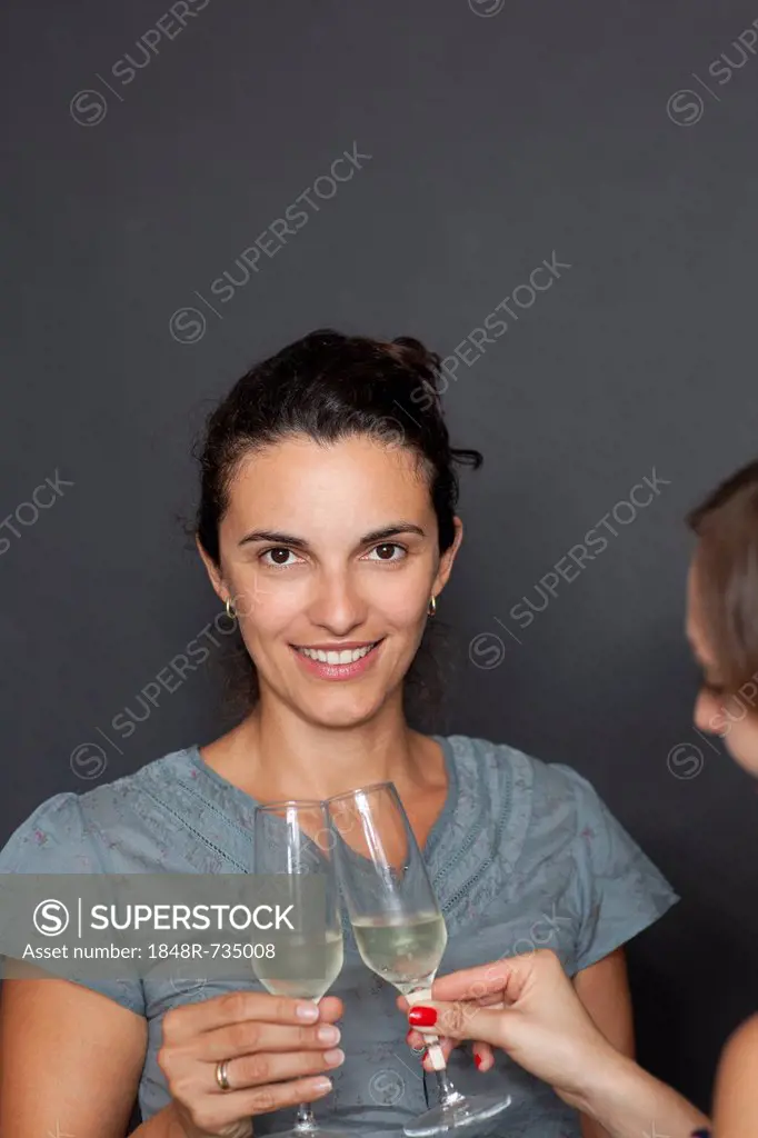 Young woman clinking glasses, sparkling wine