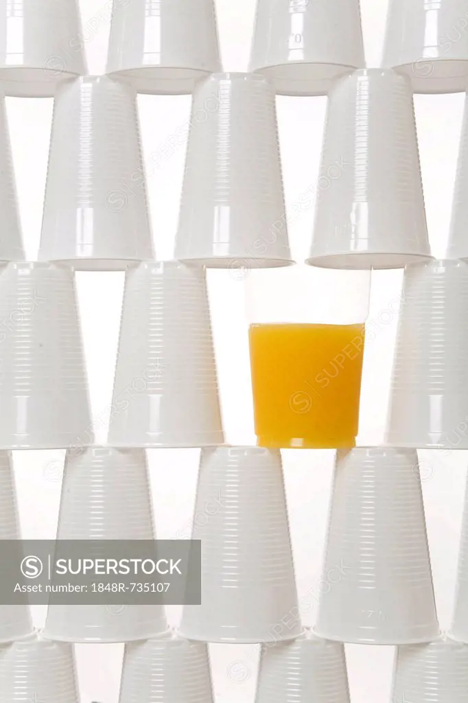 Plastic drinking cups and a glass of orange juice