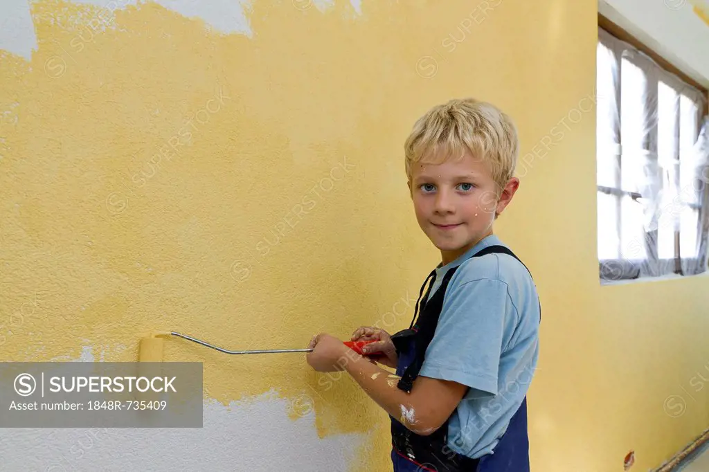 Boy, 8 years, painting a wall