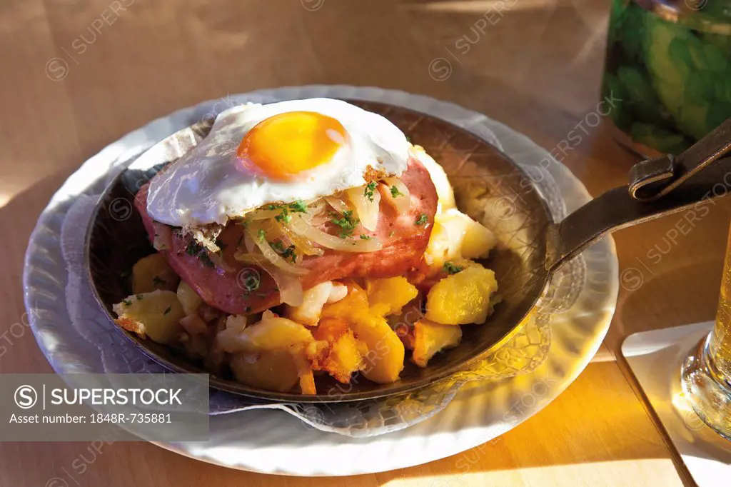 Meatloaf, fried egg and roasted potatoes in a pan
