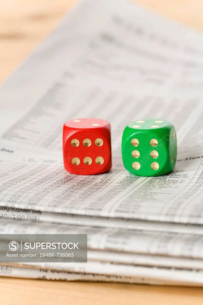 Red and green dice on a newspaper with stock prices