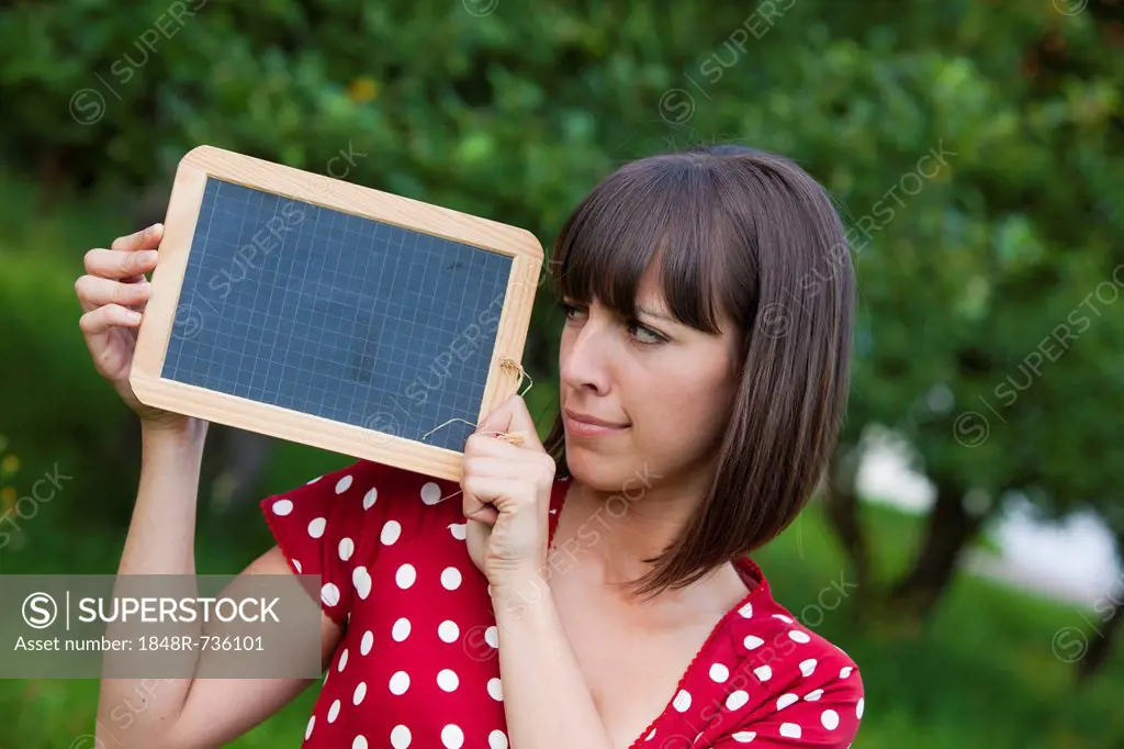 Young woman, 25, holding a blackboard in her hands