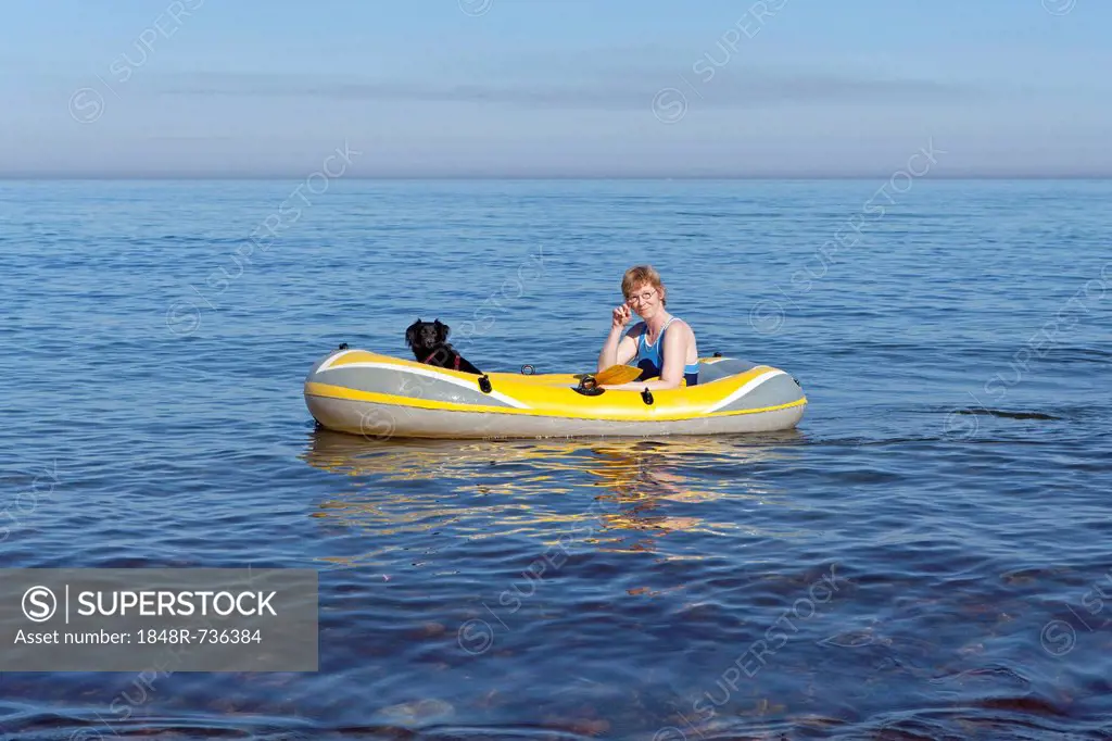 Woman with dog in a rubber boat, Kuehlungsborn-West, Mecklenburg-Western Pomerania, Germany, Europe