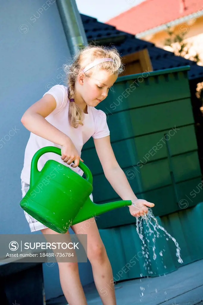 Girl with a watering can in the garden