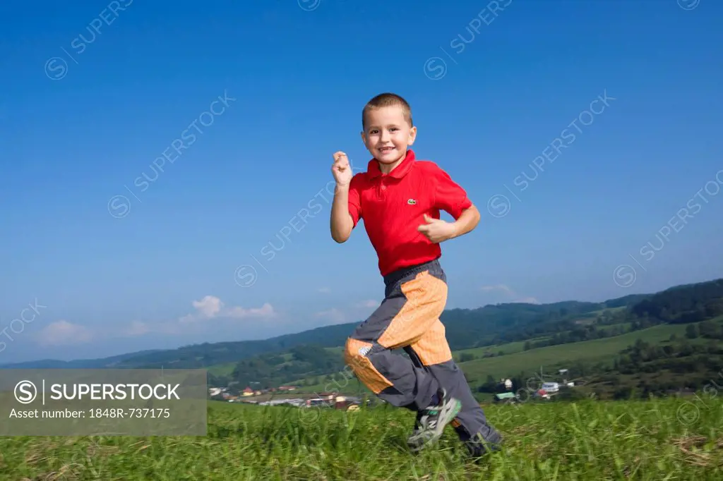 Boy, 6 years, running over a meadow