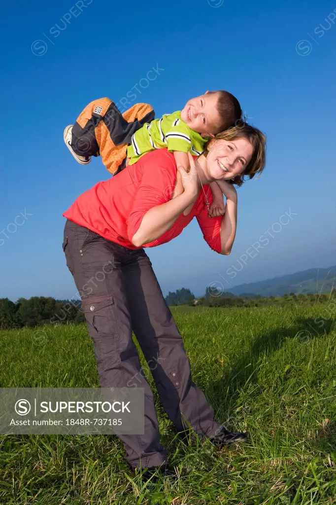 Mother, 30 years, and son, 6 years, playing in a meadow
