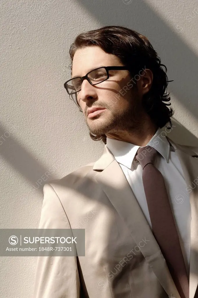 Fashion shoot, a man wearing glasses and a suit in the sunlight