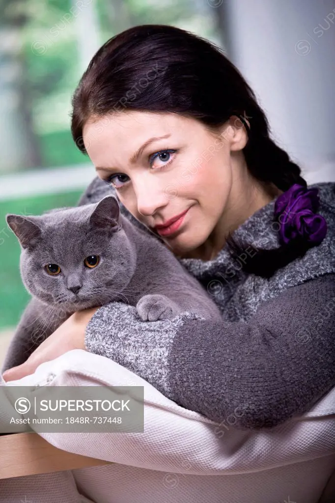 A young woman at home with a British Shorthair cat