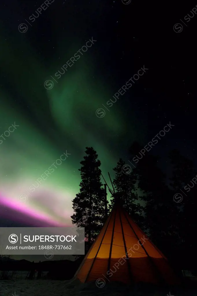 Illuminated Tipi, northern polar lights (Aurora borealis), green pink purple, near Whitehorse, Yukon Territory, Canada
