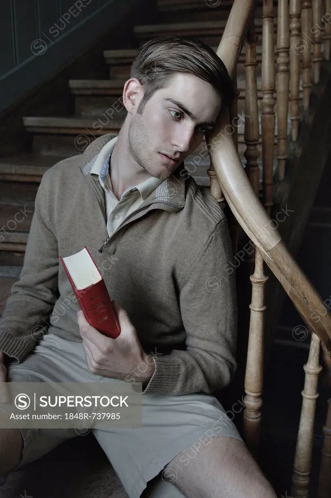 Man with book in a stairwell, nostalgic portrait