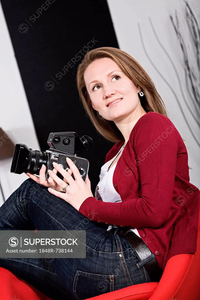 Young woman with medium format camera at home