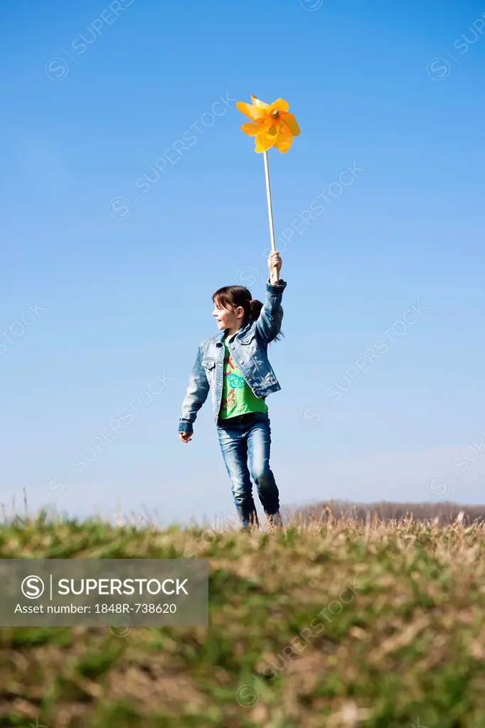 Girl holding up a pinwheel in a field