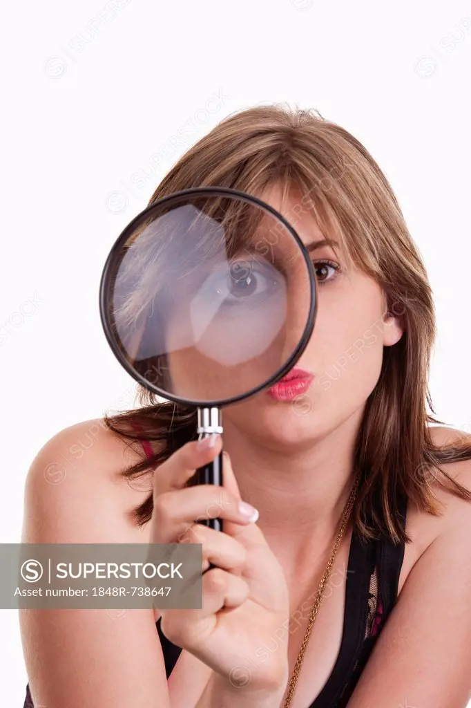 Young woman looking through a magnifying glass in her hand