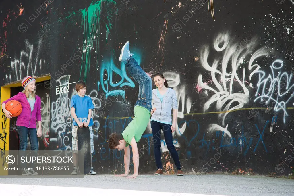 Teenagers standing in front of a wall with graffiti