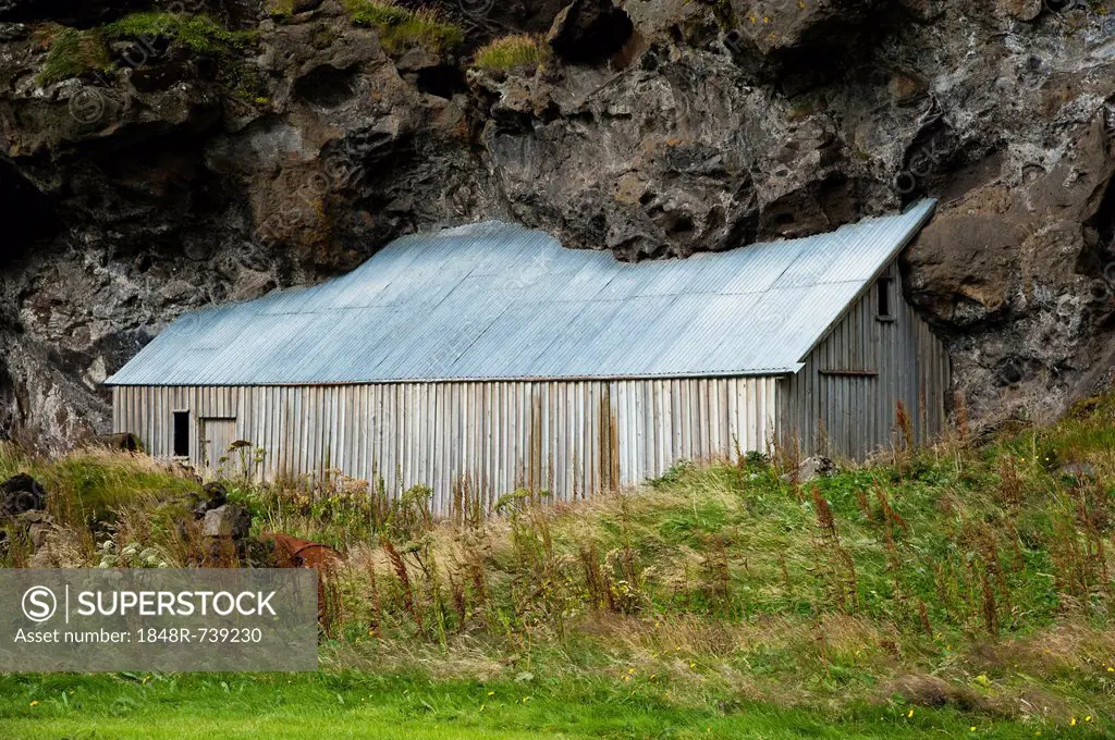 Barn built next to a rock, Austurland, eastern Iceland, Iceland, Europe