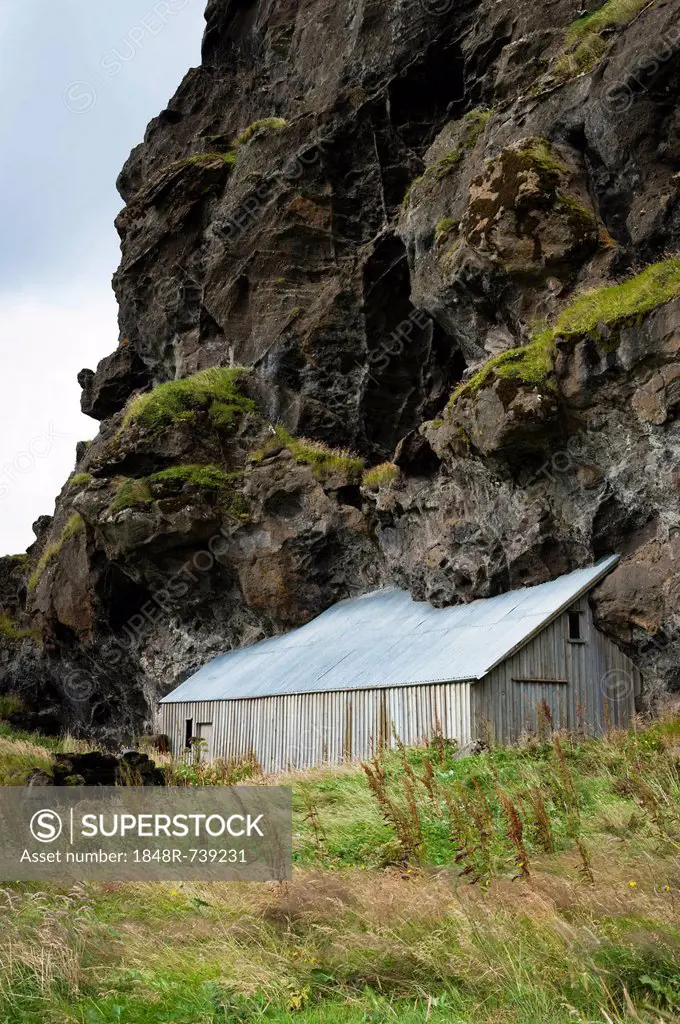 Barn built next to a rock, Austurland, eastern Iceland, Iceland, Europe